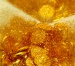 Gold sand and gold coins  close-up