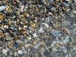 Wet brilliant pebble and sea wave