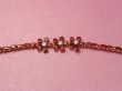 Jewelry bracelet with garnets on pink background