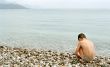 Boy, sea and pebble