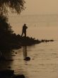 Silhuette of alone fisher near sunset river