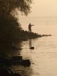 Silhuette of alone fisher near sunset river