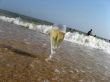 Glass of a cold champagne in warm sea waves