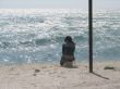 The girl in loneliness sits at sea coast