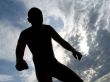 A black silhouette of a young guy in the sky
