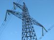 Powerline tower seen from below against blue sky