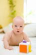 Baby playing with toy on bed