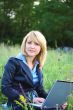 Businesswoman on grass with laptop #1