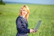Girl with laptop stay on meadow