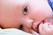 Baby`s face looks at camera close up