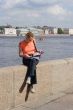 Girl reading magazine on canal border in Saint Petersburg