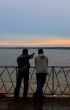 Two men on a river bay look at sunset #1