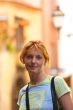 Pretty red-headed girl on street look at camera