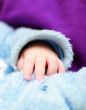 Baby`s hand on the fur clothes