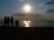 Silhouette of people looking at windsurf at sunset