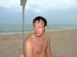 a wet young man sitting day at the beach