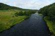 deep blue waters of the river, green grass and blue sky