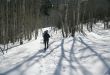 Snowshoe hiker, shadows of aspens