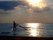 The guy drags the windsurf on a sunset