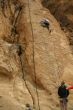 Woman belaying a climber on rock face