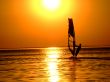 Silhouette of a windsurfer on waves of a gulf