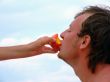 The female hand feeds the guy with a peach