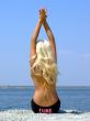 The girl-blonde sits on coast of a gulf