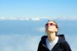 smiling girl looking in the blue cloudy sky with copyspace