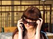 A smiling girl in sunglasses talks by a phone2