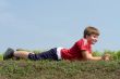 boy lays on a grass
