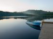 boat reflecting in calm waters of forest lake