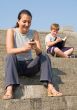 girl with mobile. boy reads book