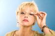 blonde adult businesswoman holding glasses and looking through