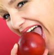 blonde woman with a peach on a red background