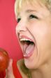 blonde woman with a peach on a red background
