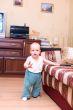 Little boy stand on hardwood floor in typical home interior