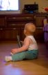 Cute little boy hold remote control and watching TV at home