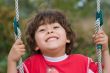 young boy swinging and smiling