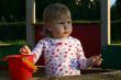 Little girl in sandbox looking away