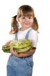 Little girl holding zucchini