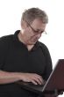 Senior man answering on e-mail from laptop