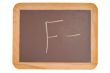 Chalkboard with an F minus written on it