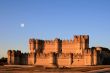 The fortress of Coca (Spain) at dusk with full moon