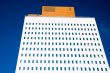 bright white office tower against blue sky
