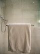 White Towel on Rack on Wet Glass Shower Door