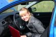 young woman with notebook in car.