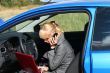 young woman with notebook in car