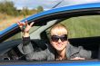 Young woman in a car with key