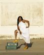 African American woman with foot on suitcases