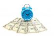 Alarm clock over a fan of money